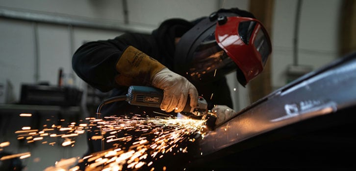 Manufacturing industry worker grinding metal